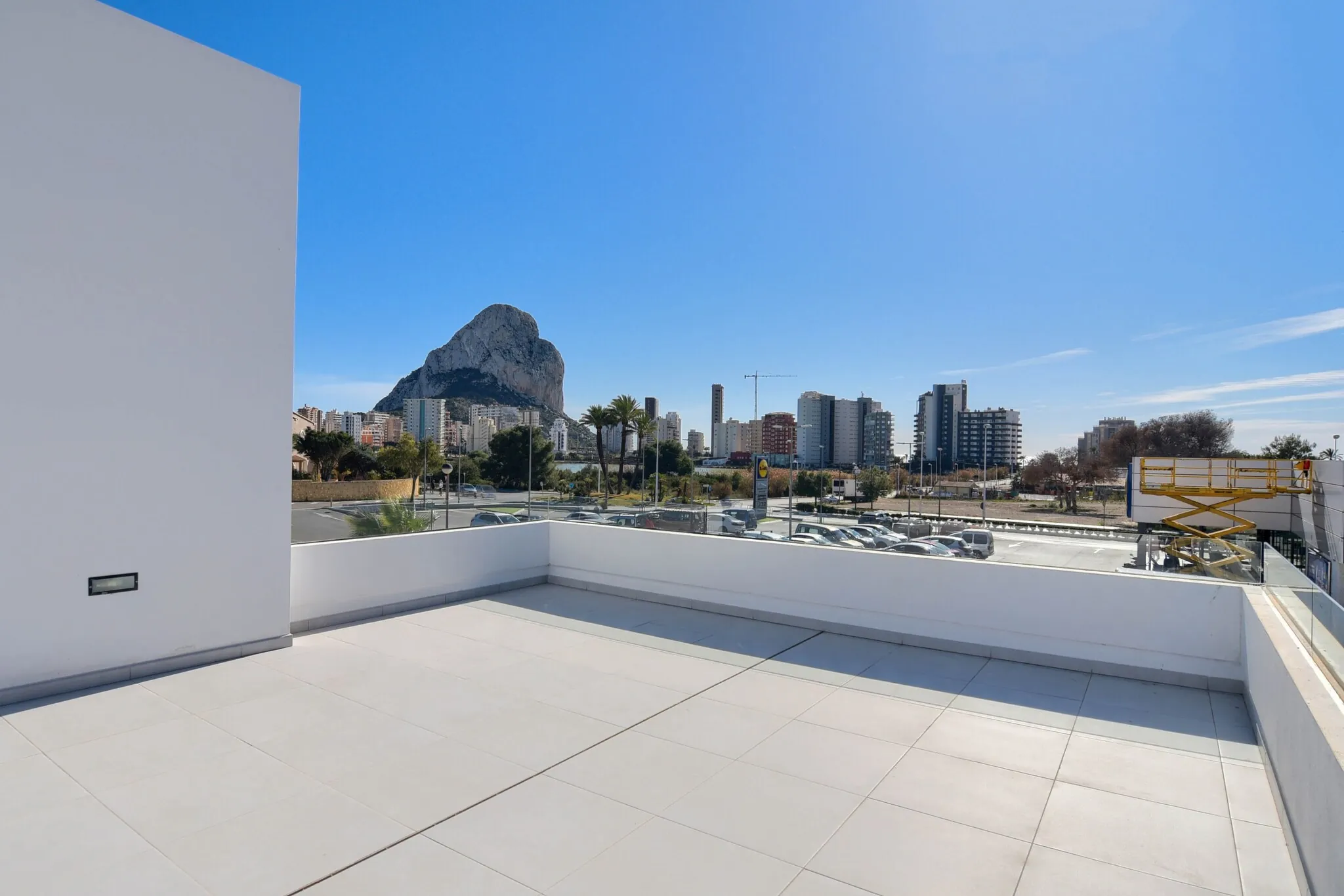 Het dakterras: een wit betegeld dek met borstwering, en daarachter de Peñón de Ifach en de skyline van Calpe.